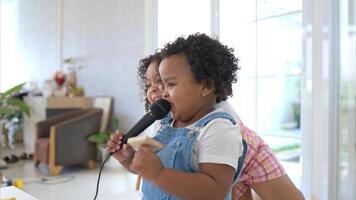 The older sister and younger sister clutching a microphone and sings cheerfully in the living room photo