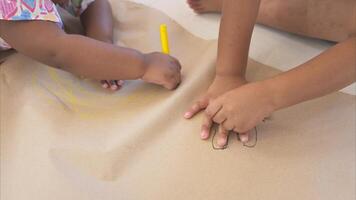 The older sister and younger sister sit on the floor and drawing hand in the living room photo