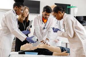 Group of people learning how to make first aid heart compressions with dummies during the training photo