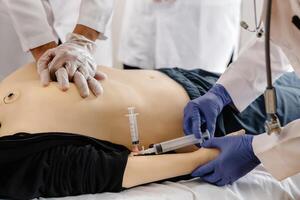 Group of people learning how to make first aid heart compressions with dummies during the training photo