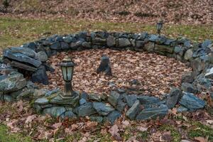 A rustic stone outdoor design surrounded by dry autumn leaves and vintage lanterns in a Czech garden photo