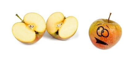 An apple with a face drawn on it and a half eaten apple photo