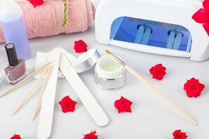 Manicure and pedicure tools on a table with flowers photo