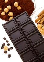 Chocolate with coffee beans, cocoa powder, cinnamon and dried orange photo