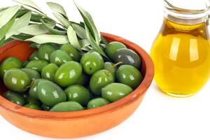 Olive oil and branches of an olive tree photo