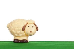 A white chocolate sheep on a green field photo