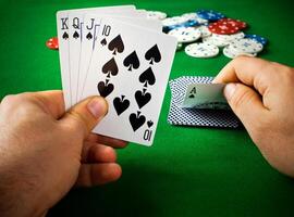 A person holding a pair of cards and playing cards photo