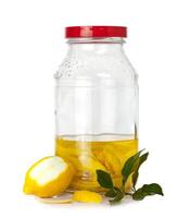 A jar of lemon oil with a lemon slice and a leaf photo