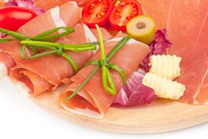 A plate with sliced ham, tomatoes, and cheese photo