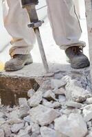 A man is using a hammer to break up a wall photo