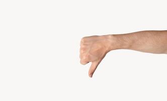 Millennial guy showing thumb down gesture, expressing negativity over light background, copy space. Panorama photo