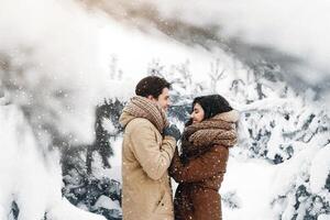 Winter Love Story. Man Holding Girlfriend's Hands Smiling Looking Into Her Eyes Standing In Beautiful Snowy Forest. Panorama photo