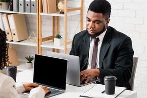 Young black man working with his female colleague, feeling bored, doing dull task at open space company office. Successful coworking and collaboration concept. Free space photo