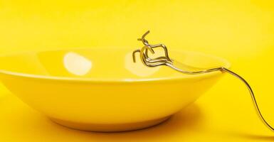 folded and deformed fork resting on an empty plate. photo