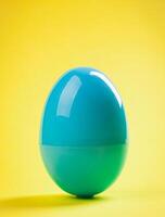Blue plastic egg close up on yellow background photo