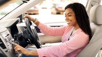 Road Playlist. Side View Profile Portrait Of Happy Black Woman Driving Car And Listening To Music On Auto Audio System, Checking Automobile Options During Test Drive Pushing Button On Turning On Radio photo