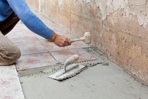 Tiler works with flooring. photo