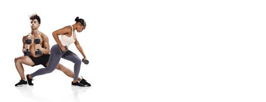 Two individuals engage in strength training with dumbbells in a well-lit fitness studio. The man performs a squat while the woman focuses on a bent-over row, demonstrating their dedication. photo