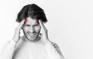 Headache concept. Man holds on to head, highlighted by red spots photo