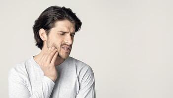 Man in pain. Beautiful young man feeling toothache, free space photo