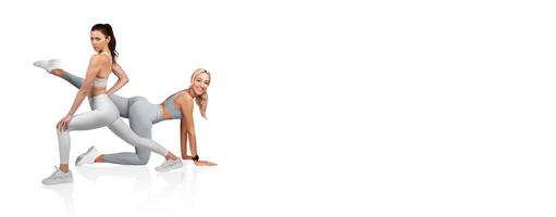 Two fitness models display dynamic workout poses in matching light gray athletic outfits. The setting highlights their strength and flexibility, promoting a healthy lifestyle. photo
