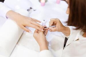 A skilled technician is applying polish to a woman's nails in a fashionable salon. The atmosphere is relaxing, with soft lighting and pampering services in focus. photo