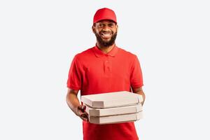 Pizza Delivery. Black Pizzeria Worker Courier Man Delivering Pizza Holding Boxes Standing On Yellow Studio Background. photo