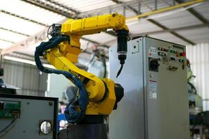 A yellow robot is standing in front of a machine photo