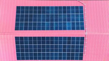Two solar panels on a pink building photo