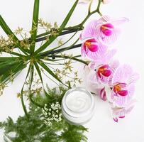Face cream with herbs and pink orchids photo