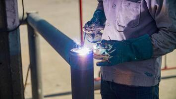 A man welding a metal pipe with a welding torch photo
