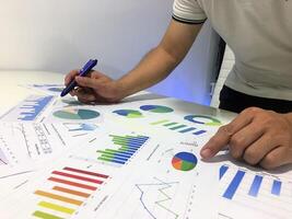 A man is working on a graph paper with a pen photo