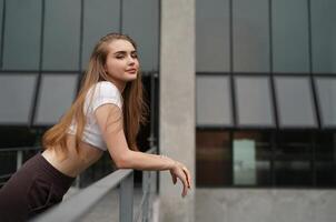 A young woman leaning against a railing photo