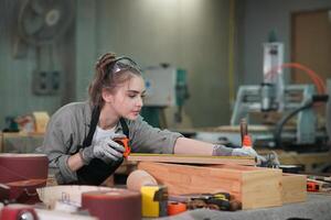 A woman working on a wooden box in a workshop photo