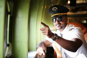 A man in a pilot's uniform pointing at something photo