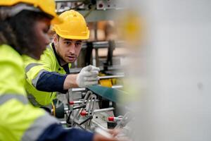 Two workers in safety gear working on a machine photo