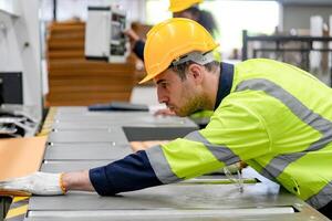 A man in a safety vest working on a machine photo