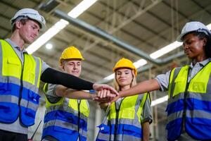 Four people in hard hats shaking hands photo