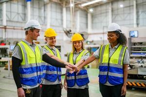 Group of workers shaking hands in factory photo