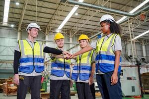 Group of workers shaking hands in factory photo