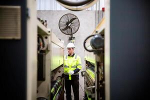 A man in a safety vest standing next to a machine photo
