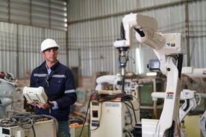 A man in a factory with a robot photo