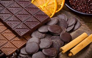 Chocolate with sliced dried orange and cinnamon sticks photo