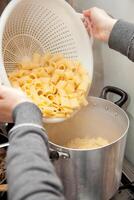 Cooking pasta with a colander photo