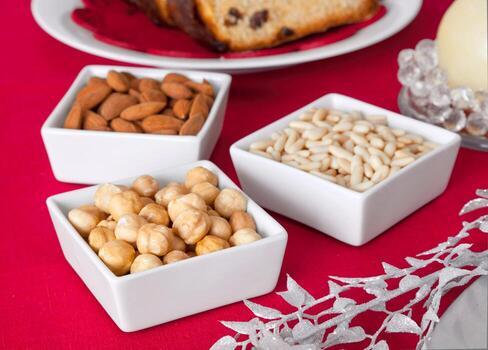 Pine nuts, almonds and hazelnuts in bowls on the Christmas table photo