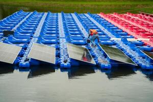 A man is working on a row of solar panels on a boat photo