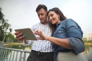 A man and woman standing in front of a tablet computer photo