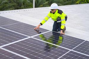 A man in a safety vest and hard hat working on a solar panel photo