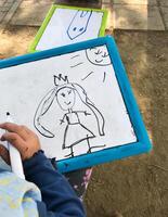 Hands of small student drawing on whiteboards photo