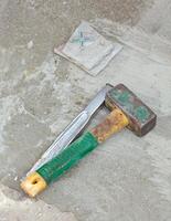 Awl and hammer on concrete flooring photo